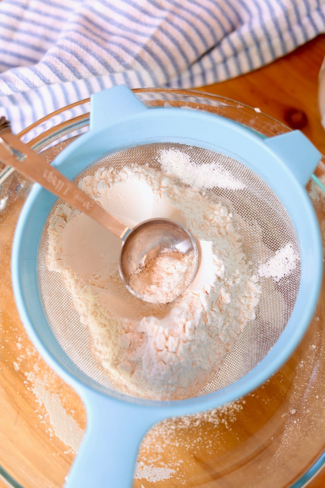 measuring spoon in flour with sieve