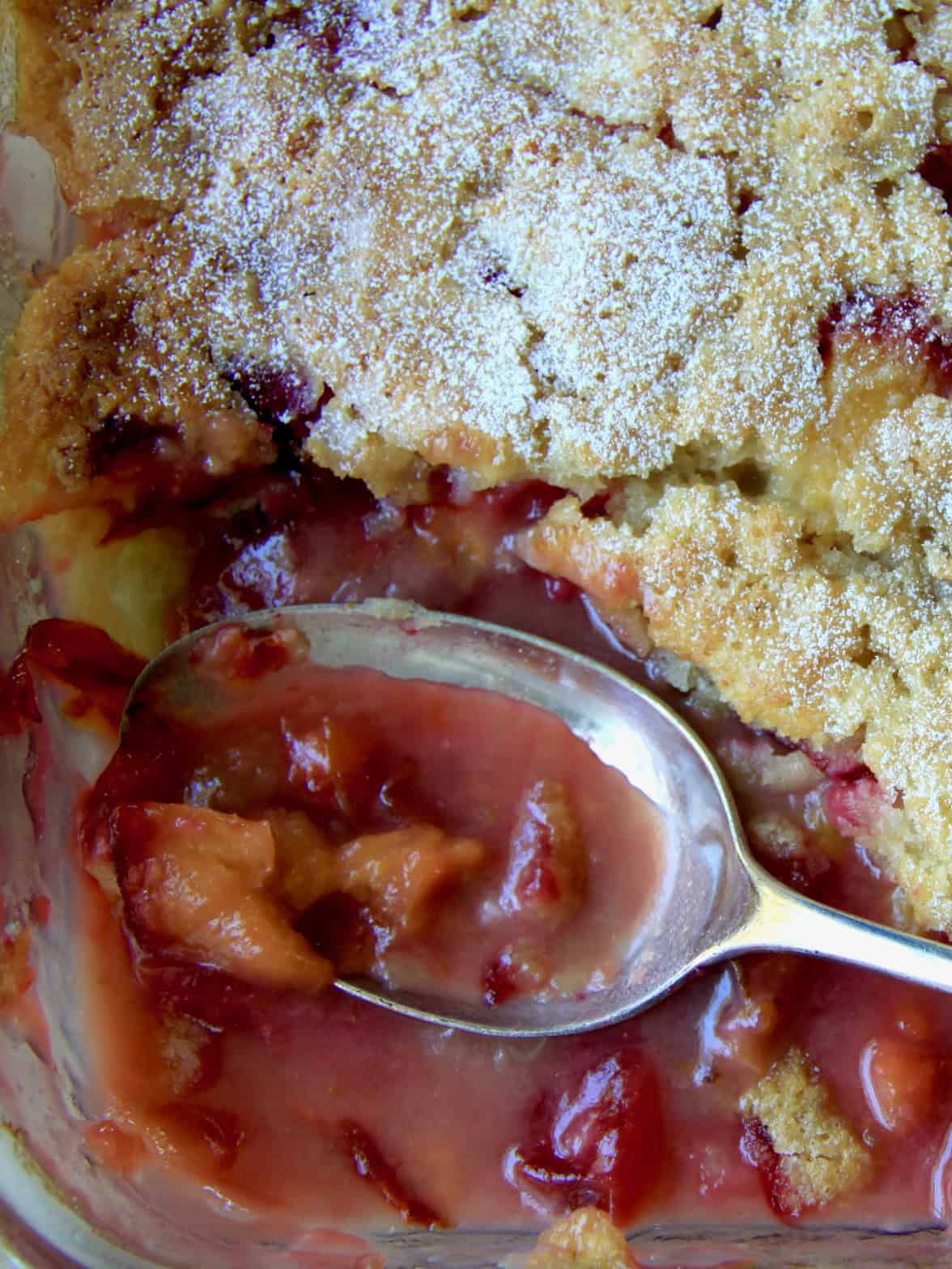 Birds eye view self saucing plum pudding with serving spoon