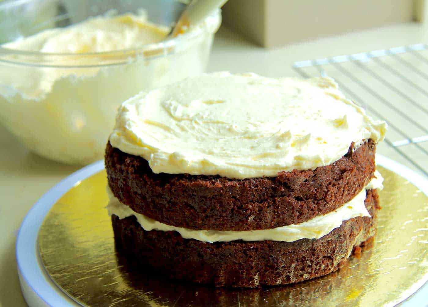 A two layered chocolate cake, frosted 'naked style' with white chocolate buttercream.