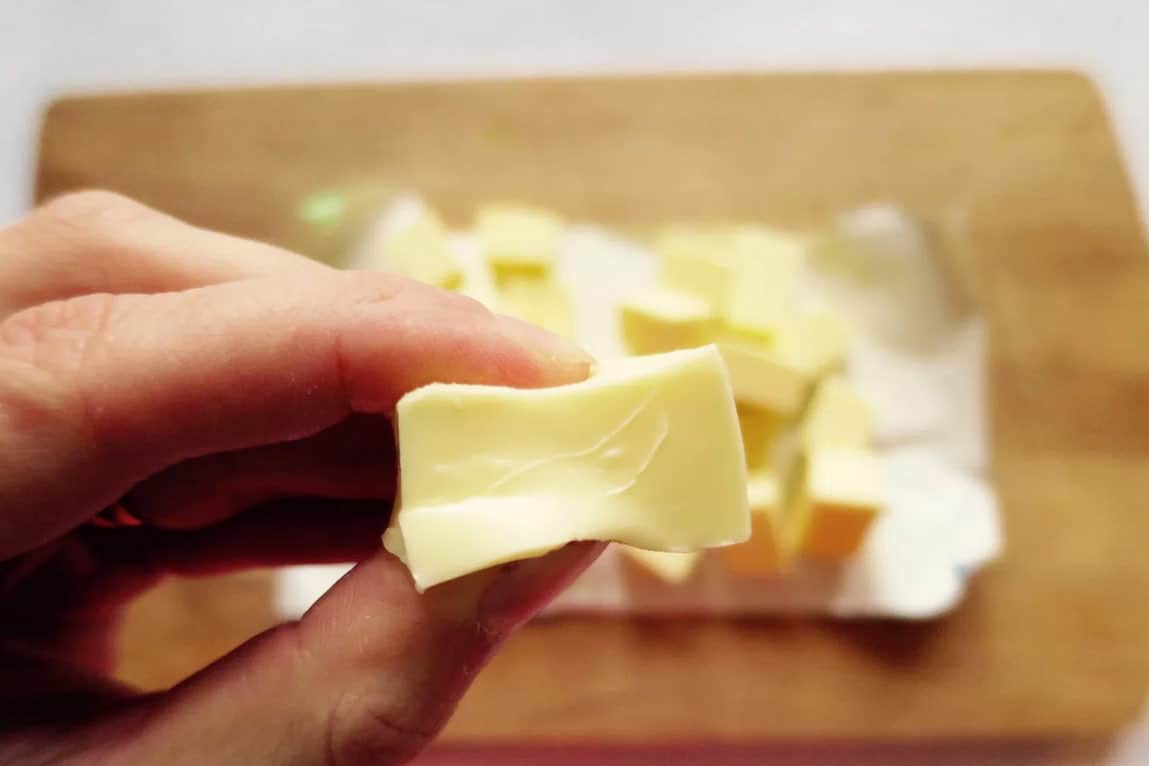 A piece of butter at room temperature, squeezed gently between fingers
