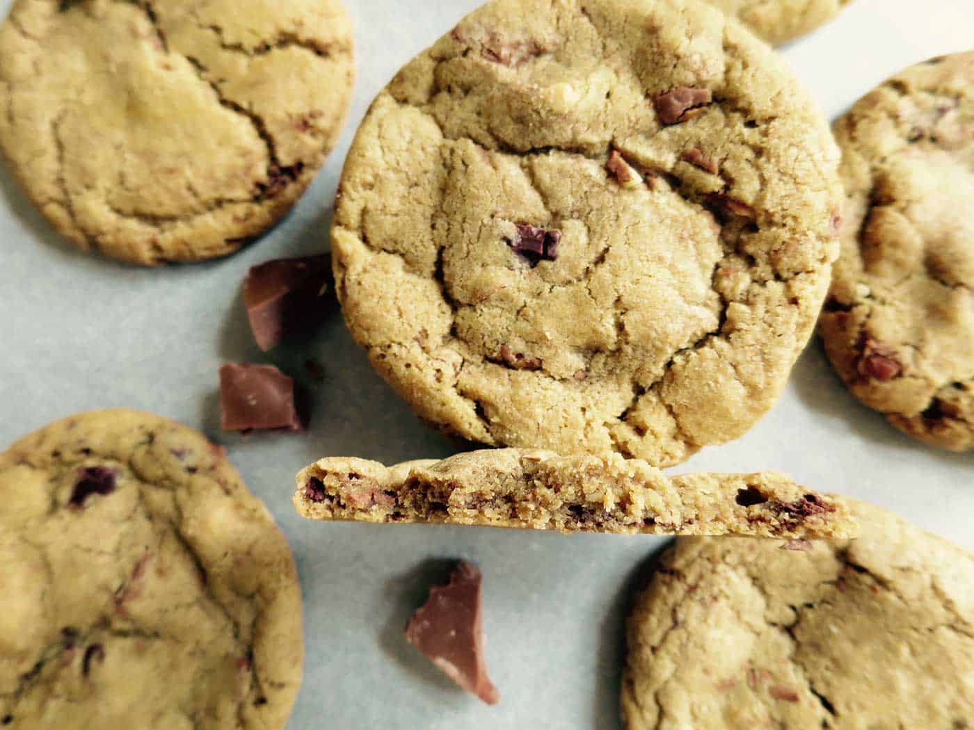 Chocolate chunk cookies on baking tray showcasing the centre of one cookie.