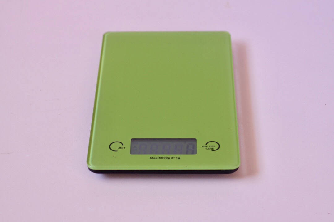 Green digital scales on a pink board.