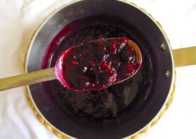 Spoon of berry compote directly from the pot