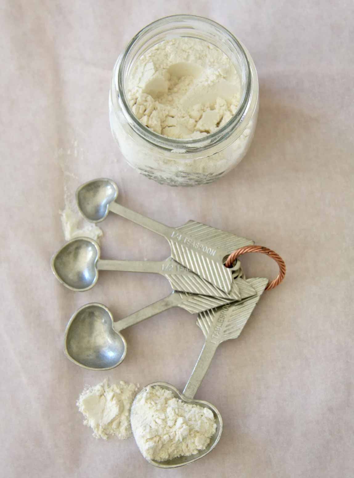 A jar of flour and measuring spoons