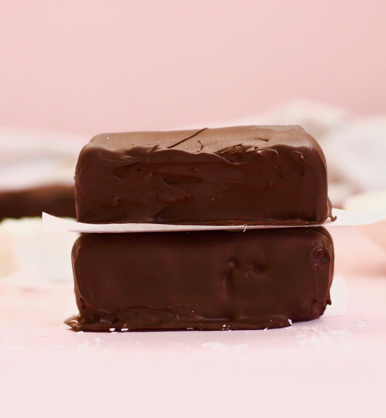 Two bounty bars which have been fully covered in chocolate, stacked on top of each other