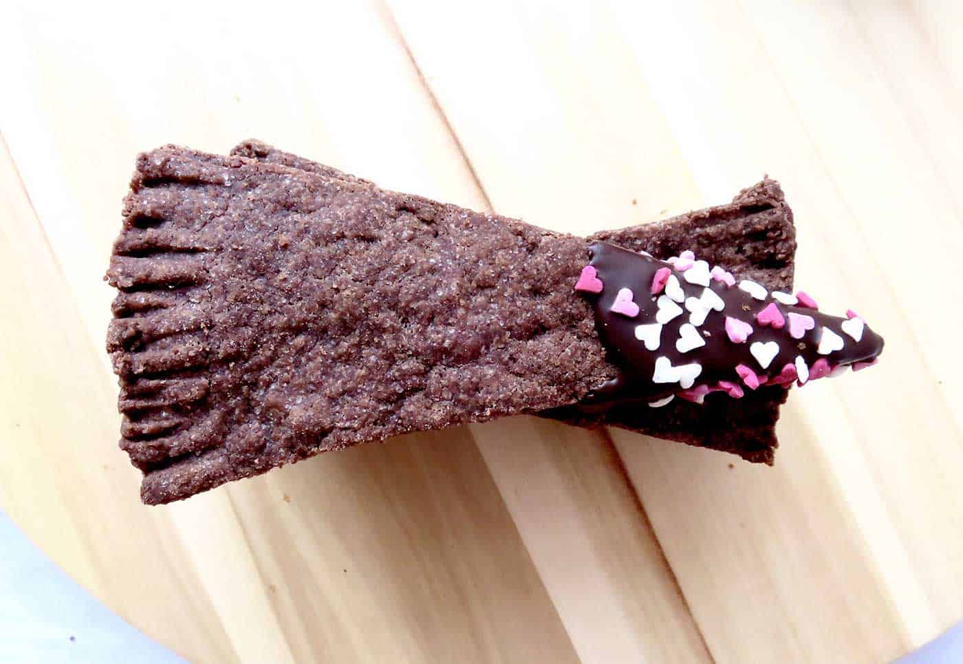 Pieces of chocolate dipped shortbread, stacked on top of each other. The tips are covered in chocolate and sprinkles