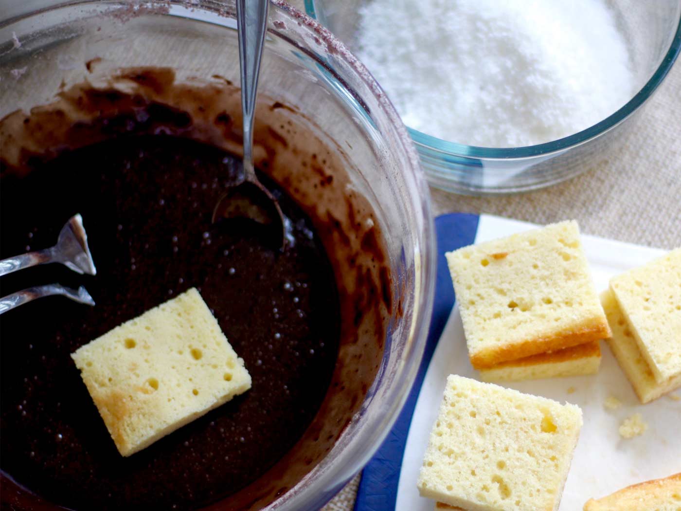 A bowl of chocolate sauce with pieces of vanilla sponge ready to be dunked in.