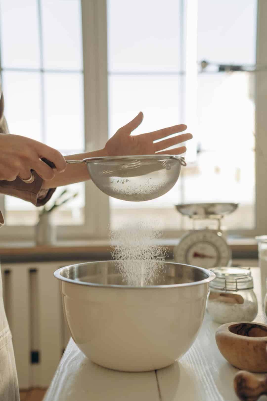 Baker sifting louise cake slice into bowl