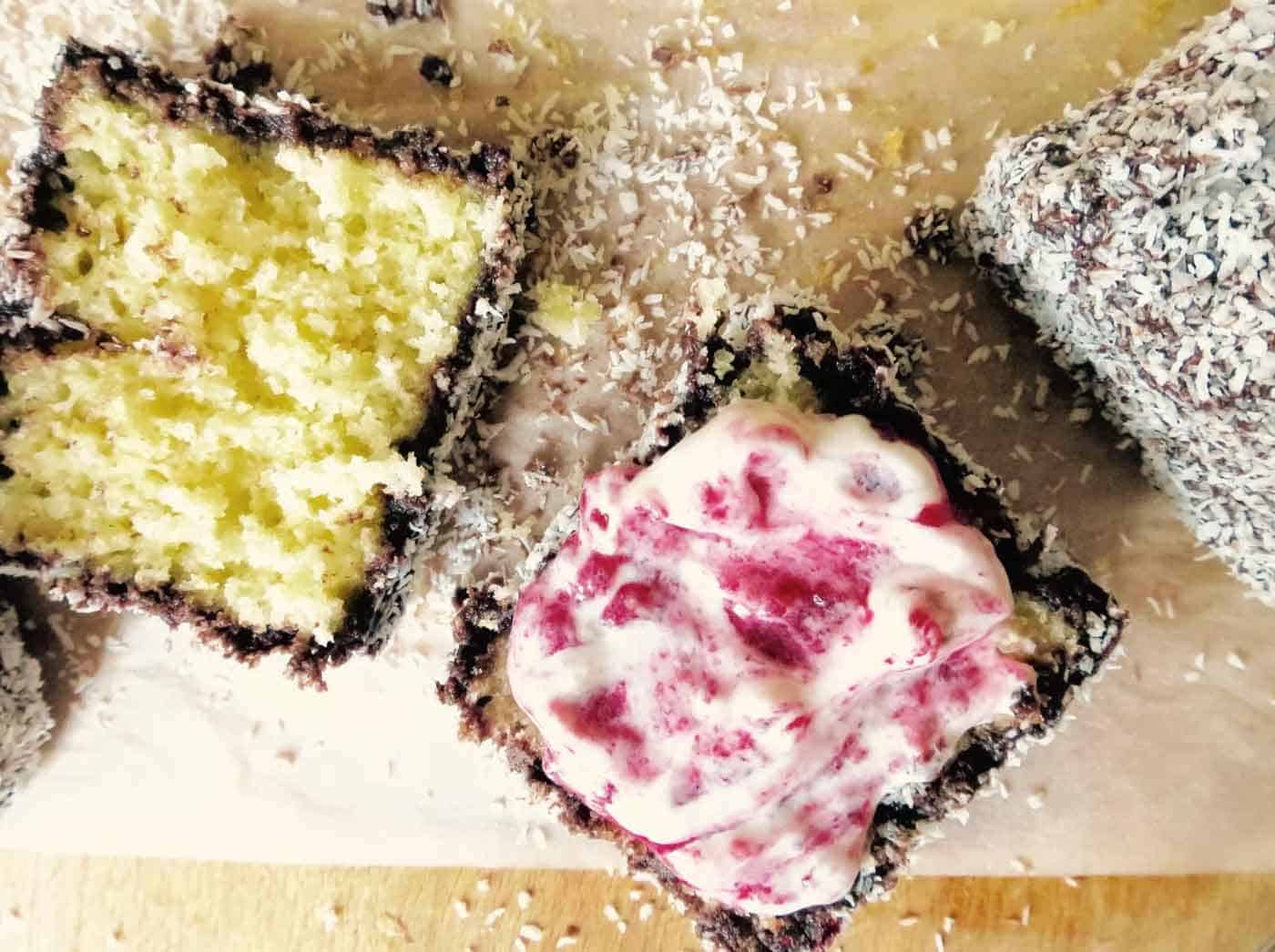 A lamington cut in half with raspberry filling.