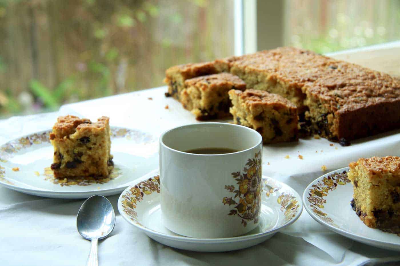 Sultana cake cut into pieces with a cup of tea