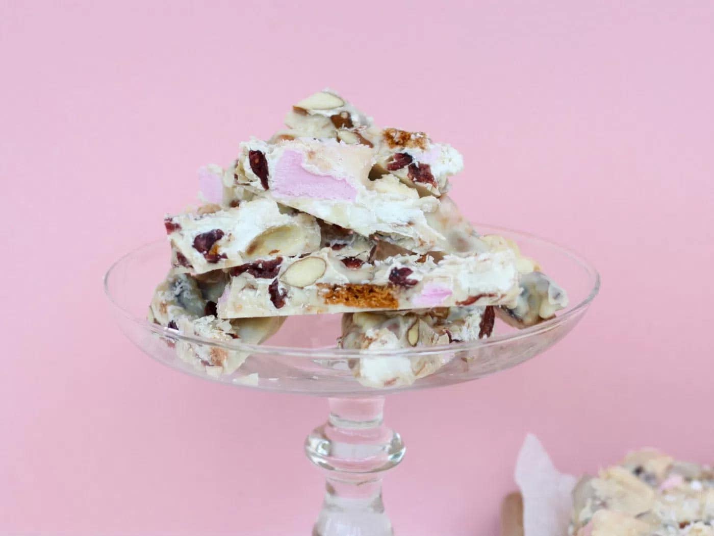 A glass stand with pieces of white chocolate rocky road stacked on it