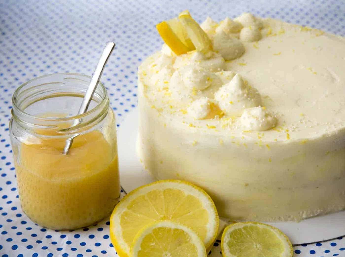 Lemon cake with lemon curd in a jar on the side.