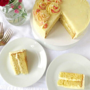 Vanilla cake with two slices cut and served on plates. Forks near by.