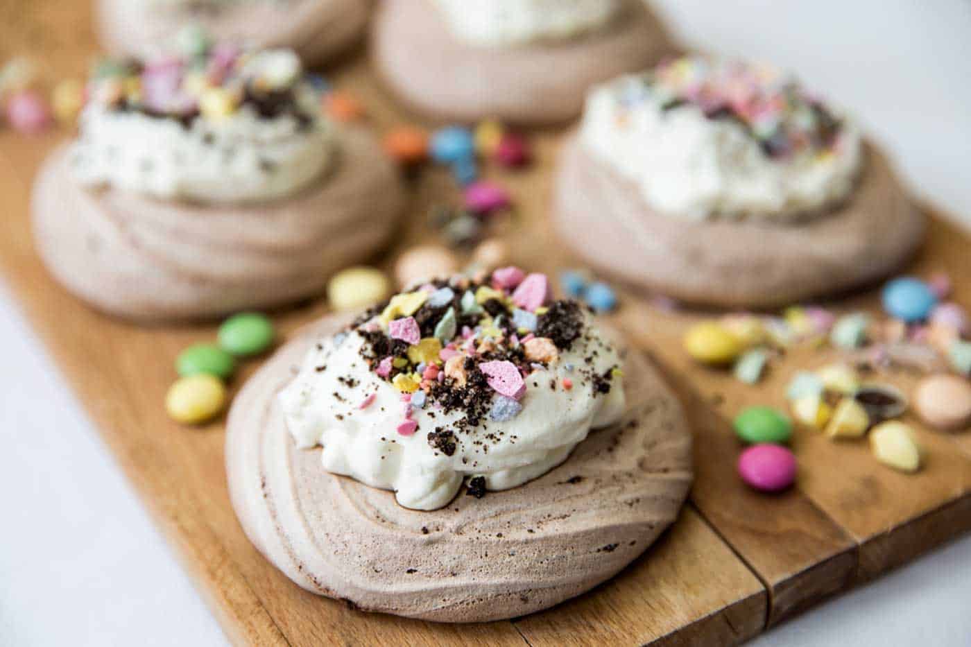Decorated Easter meringue nest with cream and sweets.