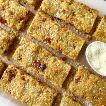 Ros of deliciously healthy apricot and coconut bars on a board. They are all sprinkled with extra icing sugar.