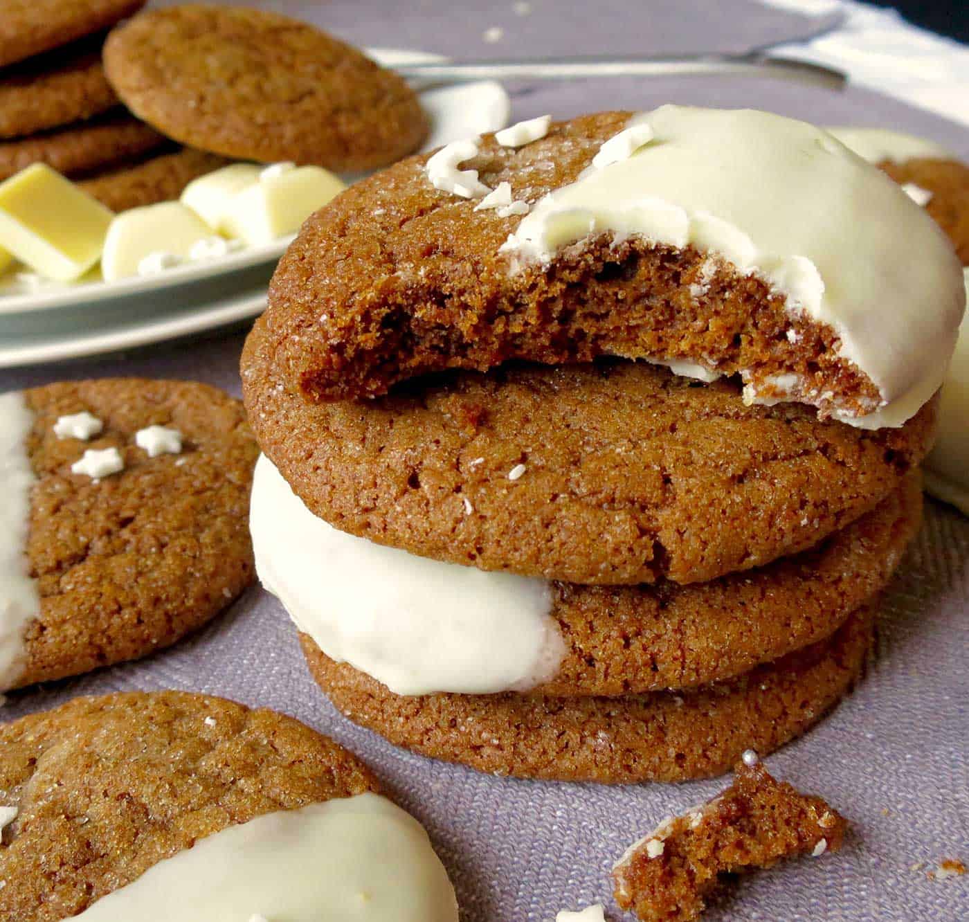 A stack of ginger cookies with a bite taken out of the top cookie.