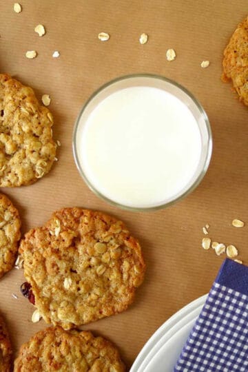 Oatmeal cookies and a glass of fresh milk on brown baking paper.