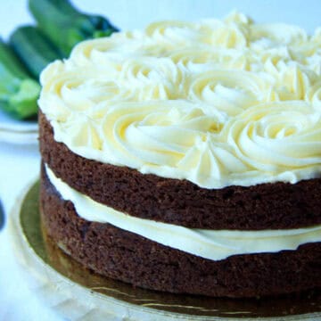 A two layer Zucchini Chocolate Cake decorated with buttercream piped rosettes and filling.