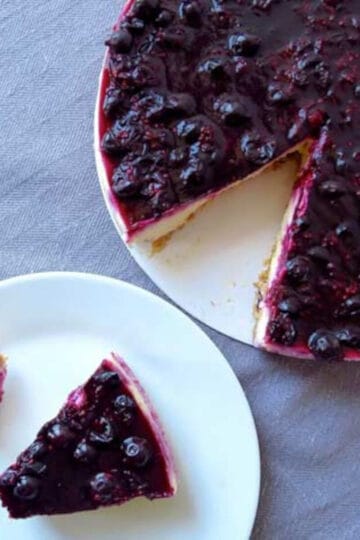 A berry cheese cake which has been sliced and served on a plate.