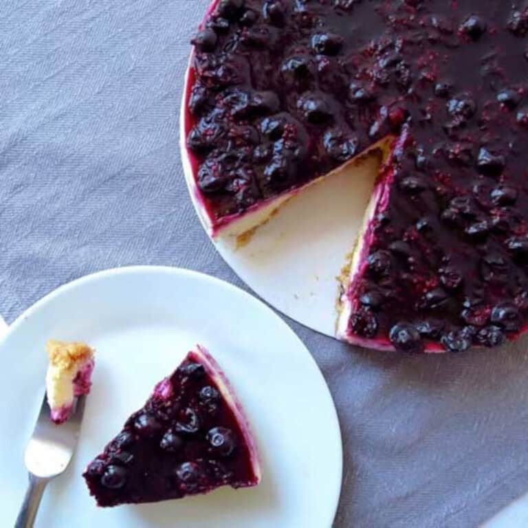 A berry cheese cake which has been sliced and served on a plate.