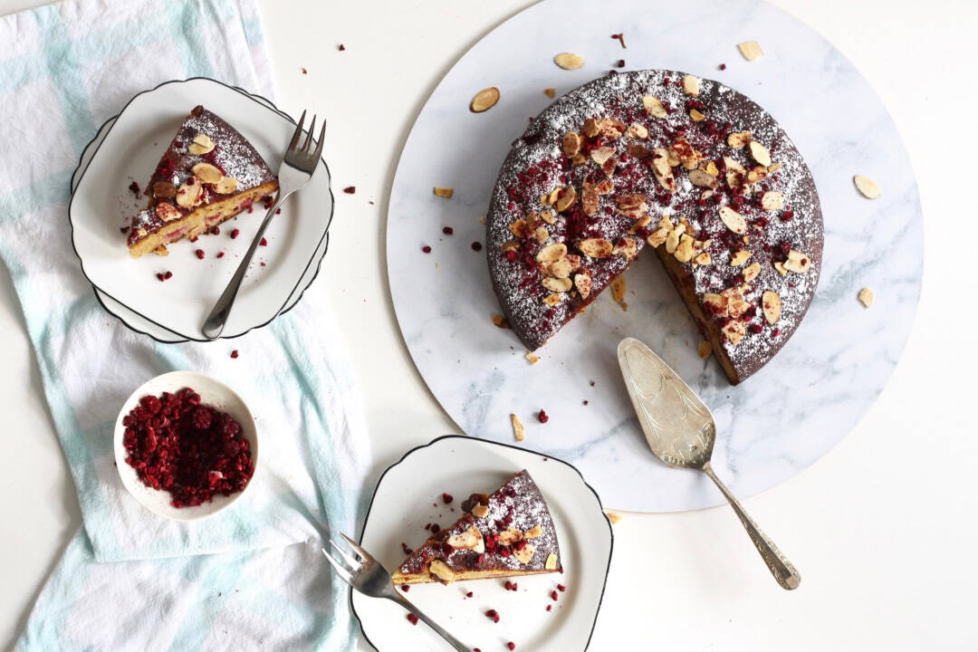 Gluten dairy free almond raspberry cake with two slices of it served on plates.