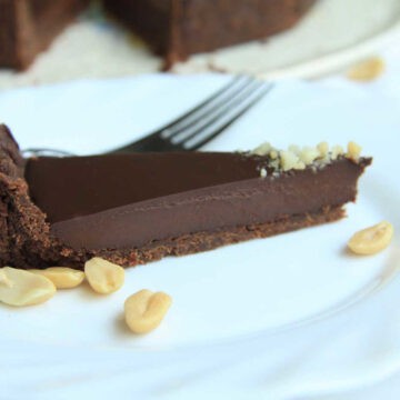A slice of velvet chocolate tart. The chocolate base has a melt-in-your-mouth tender crumb and the chocolate ganahce filling is creamy and velvet in texture.