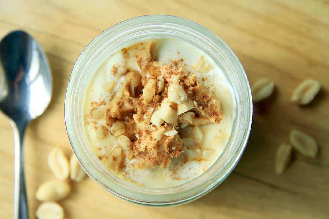 A top view of the peanut butter overnight oats. A dollop of peanut butter with fresh nuts on the top to decorate.