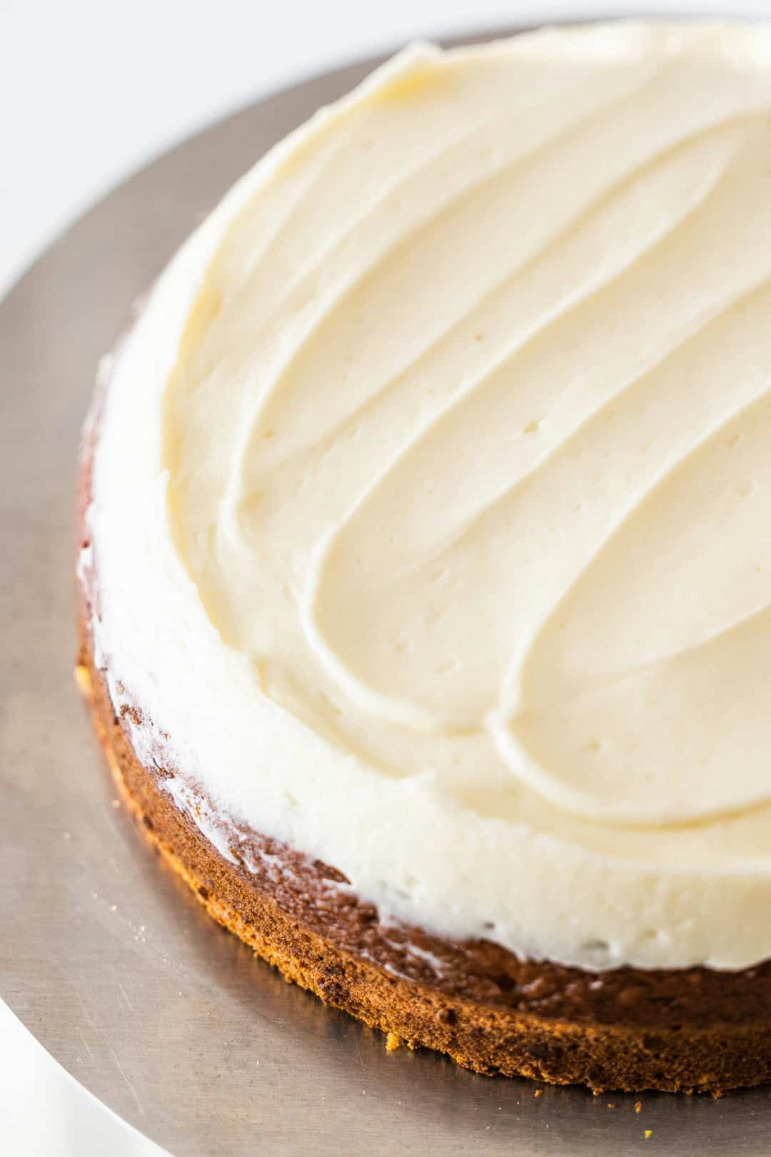 A top view of carrot cake with perfect cream cheese frosting on top.