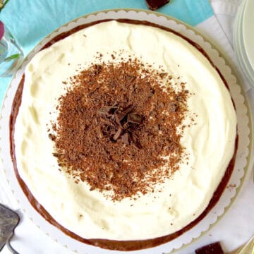 A top view of the velvet chocolate cheesecake. It has a creamy sour cream topping which is decorated with chocolate shards.