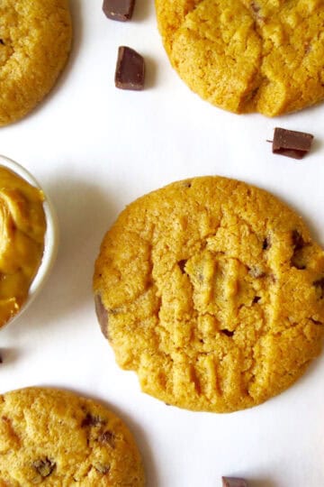 Chocolate Chunk and Peanut Butter Cookies on a white board with a little bowl filled with peanut butter next to it.