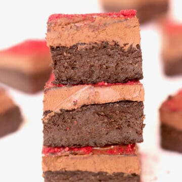 Three pieces of decadent chocolate vegan brownies. A thick layer of vegan chocolate ganache is layered on each piece.
