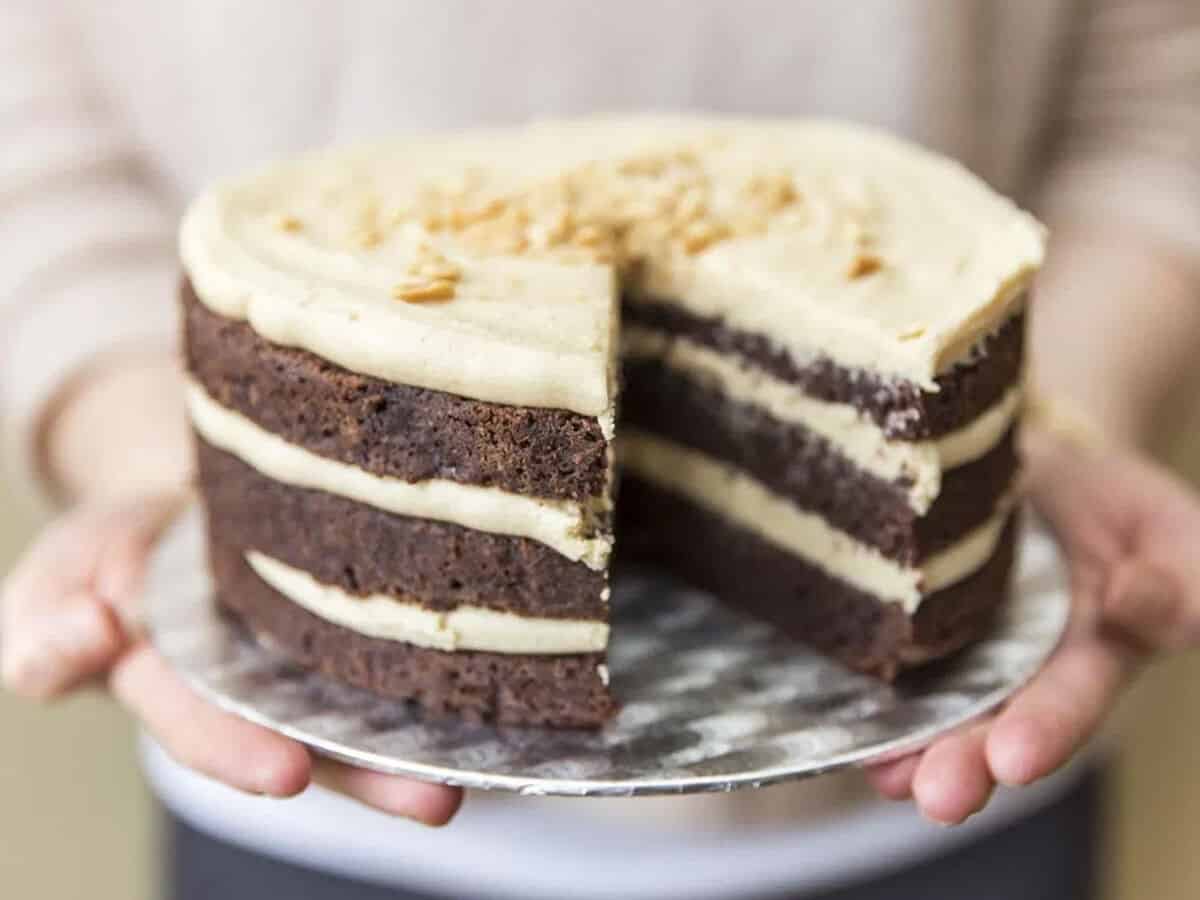 A chocolate layer cake frosted with peanut butter frosting in between the layers.