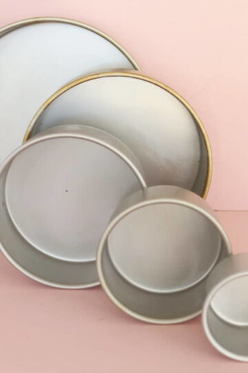 Five different size cake tins all lined up in front of each other (the largest are at the back)