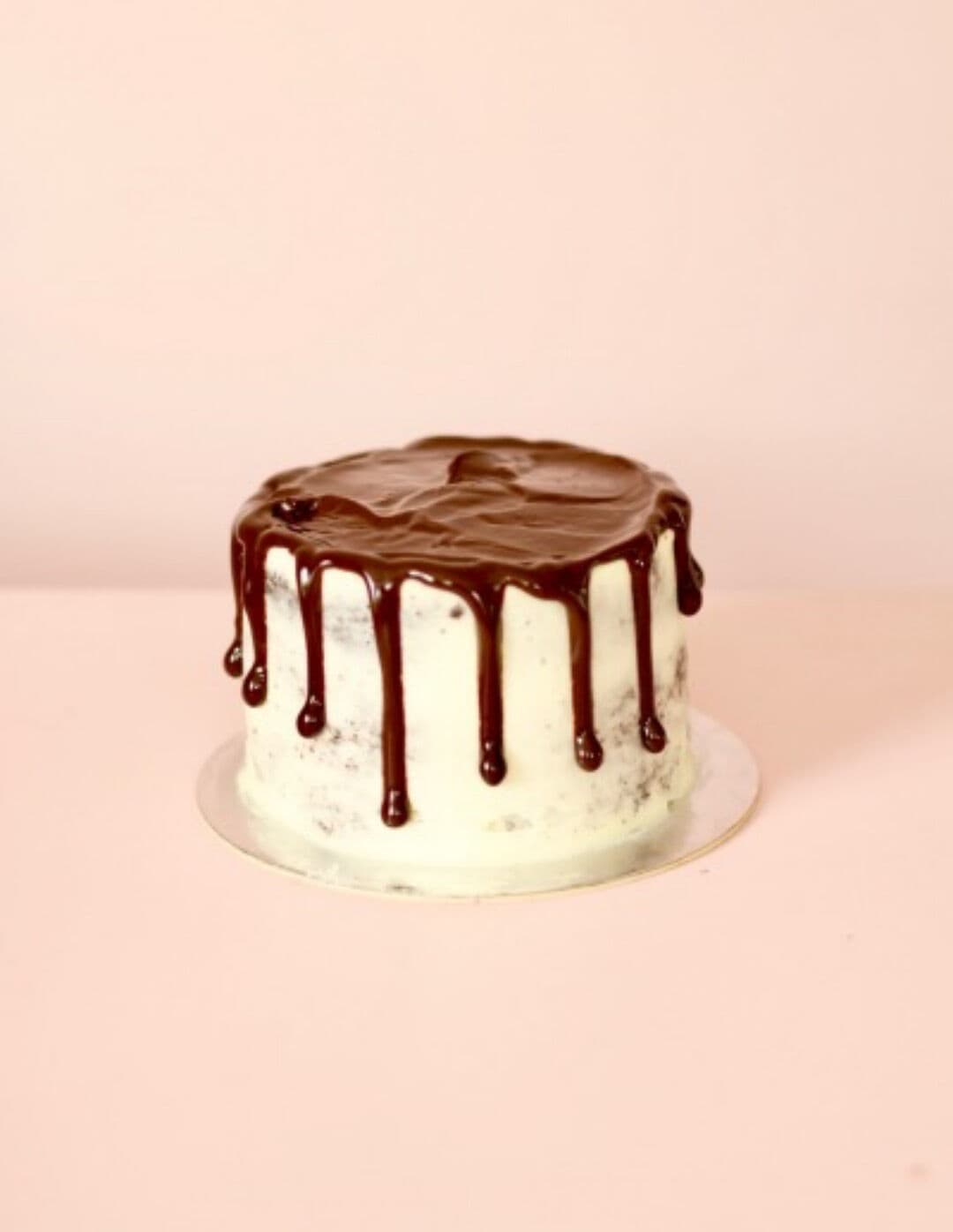 A perfectly iced mini cake with silky chocolate ganache drizzle.