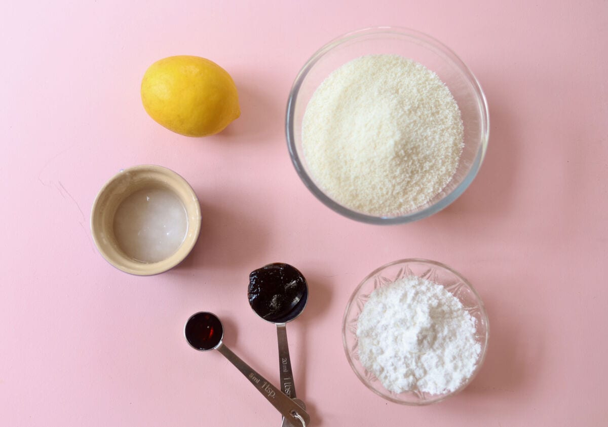 Ingredients for lemon coconut truffles laid out on a pink background.