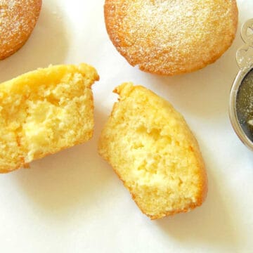 Delicious lemon muffins filled with cream cheese cut in half, showcasing the cream creamy cream cheese filling.