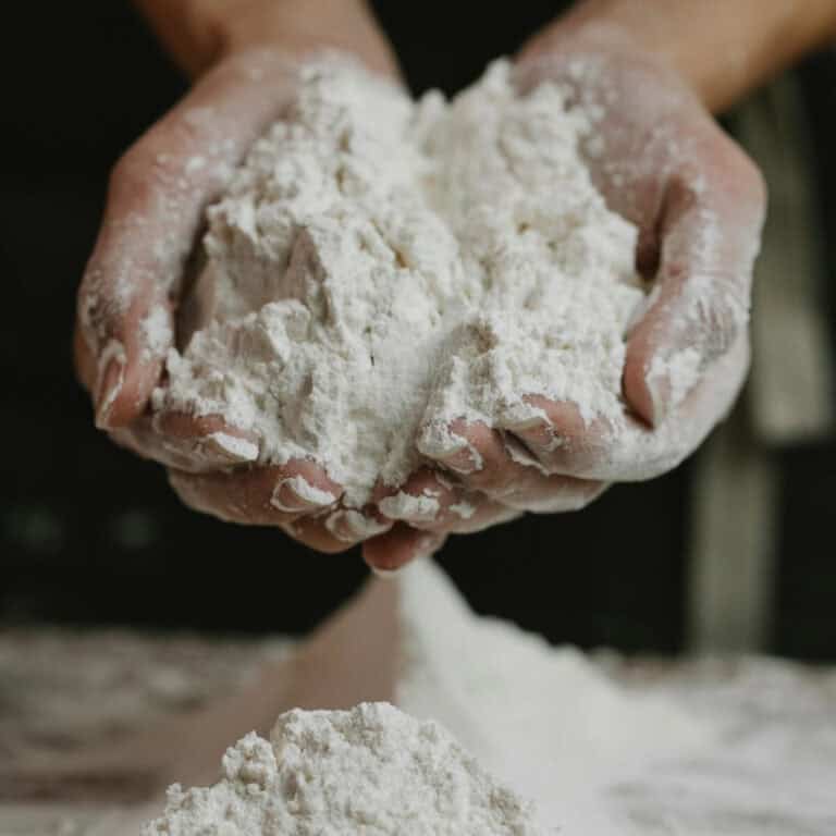 Two hands cupping a large portion of flour.