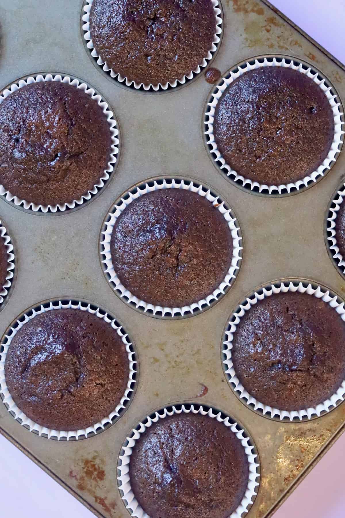 Decadent chocolate cupcakes in a cake pan straight from the oven. The cake pan is on a diagonal.