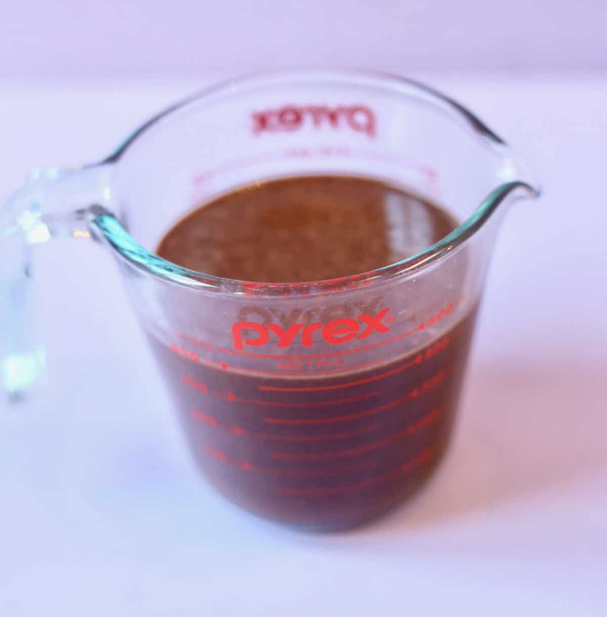 A glass pyrex jug filled with chocolate cupcake batter for easy pouring.