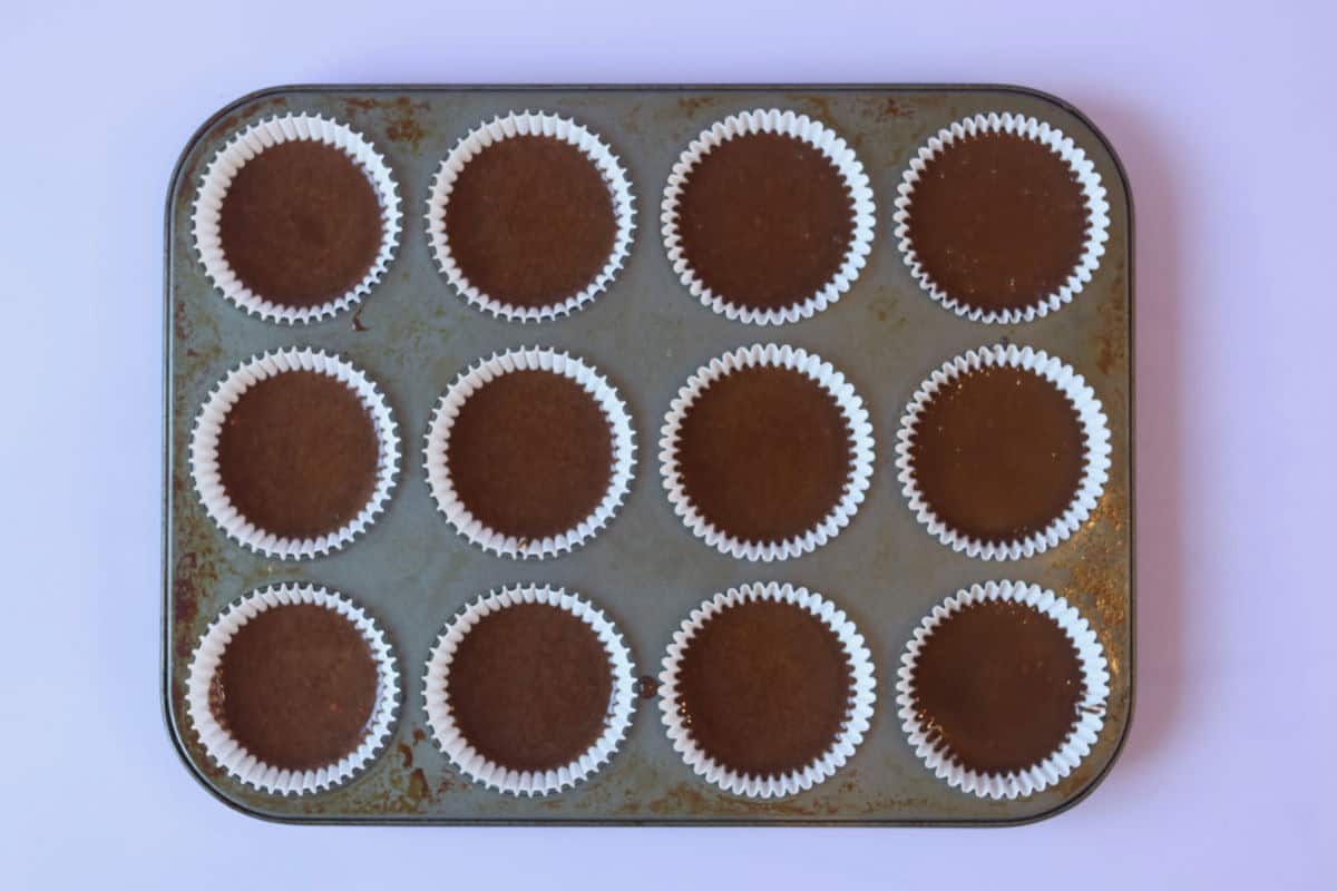 12 chocolate cupcake liners filled with cupcake batter