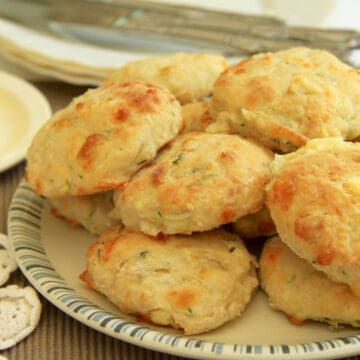 A batch of feta and zucchini scones piled high on a plate.
