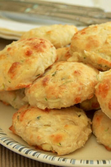 A batch of feta and zucchini scones piled high on a plate.