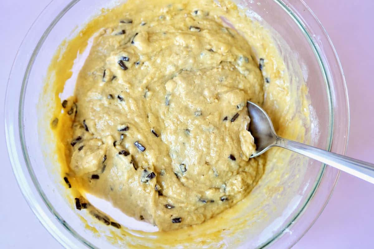 Muffin batter fully mixed with a metal spoon using folding technique. Chocolate chips have been added.